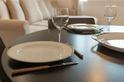 a table with plates and wine glasses on it at 2P neuf au Coeur de St Jean Cap Ferrat in Saint-Jean-Cap-Ferrat