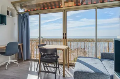 a room with a table and chairs and a large window at Appartement Rivage - Welkeys in Cagnes-sur-Mer