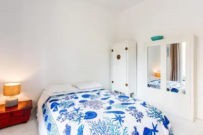 a bedroom with a blue and white bed and a mirror at Imperial AP4318 by Riviera Holiday Homes in Nice