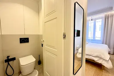 a bathroom with a toilet and a bed with a mirror at OPERA PROMENADE 4 Renovated 3 Bedrooms Balcony Sea View AC in Nice