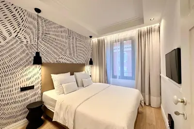 a bedroom with a white bed and a television at OPERA PROMENADE 4 Renovated 3 Bedrooms Balcony Sea View AC in Nice