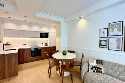 a kitchen and living room with a table and a couch at OPERA PROMENADE 4 Renovated 3 Bedrooms Balcony Sea View AC in Nice