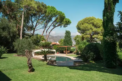 a garden with a swimming pool and trees at Charming Villa Saint-Jean-Cap-Ferrat in Saint-Jean-Cap-Ferrat