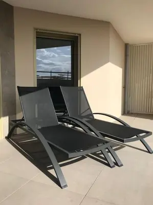 a black chair sitting in a room with a window at Blue Pearl A008 By Avecoeur in Nice