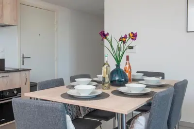 a dining room table with chairs and a vase with flowers at Blue Pearl A008 By Avecoeur in Nice