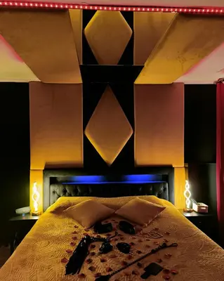 a fireplace in a living room with a mirror at La loveroom bdsm de Nice 