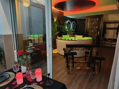 a living room with a tub and a table with a table sidx sidx at La loveroom bdsm de Nice 