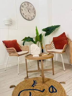a living room with a table and two chairs and a clock at Studio récemment rénové proche gare et ville in Nice