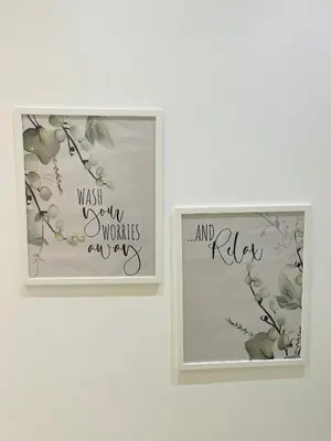 two picture frames on a wall with flowers and letters at Studio récemment rénové proche gare et ville in Nice