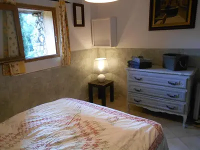 a bedroom with a bed and a dresser with a lamp at maison florentine in La Gaude