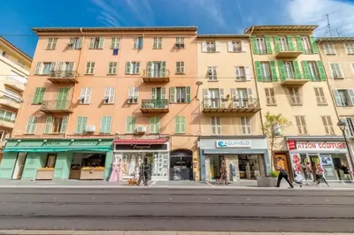 a large pink building on a city street with shops at Lovely townhouse in a lively area close to the old Nice in Nice