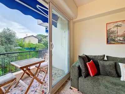 a living room with a couch and a table on a balcony at Nestor&Jeeves - SOLAR - By sea - Balcony in Nice