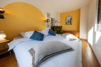 a bedroom with a large white bed with blue pillows at Spacious and bright flat close to the beach : heart of old Nice in Nice
