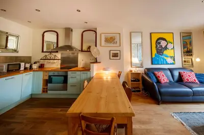 a kitchen and living room with a table and a couch at Spacious and bright flat close to the beach : heart of old Nice in Nice