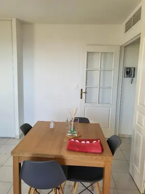 a wooden table with chairs and a red napkin on it at Nice garden in Nice