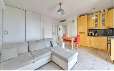 a living room with a couch and a kitchen at Nice garden in Nice