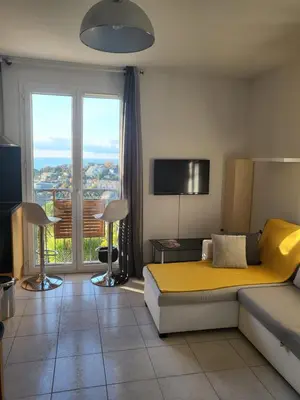 a living room with a bed and a large window at Nice garden in Nice