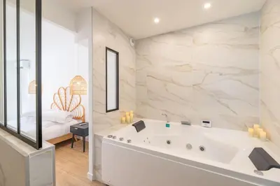 a large white bathroom with a tub and a bedroom at A/C & BALNEO in of Carré d'Or NICE #RENOVATED in Nice