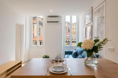 a dining room with a table with a vase of flowers at A/C & BALNEO in of Carré d'Or NICE #RENOVATED in Nice