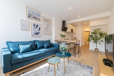 a living room with a blue couch and a table at A/C & BALNEO in of Carré d'Or NICE #RENOVATED in Nice
