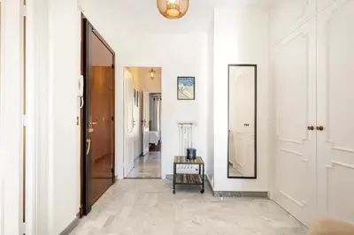 a hallway with white walls and a mirror on the wall at Eat - Sleep - Wander Chic and Cosy Flat in Nice