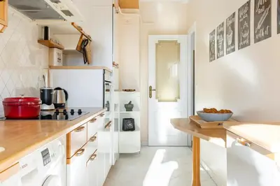 a kitchen with white cabinets and a white refrigerator at Eat - Sleep - Wander Chic and Cosy Flat in Nice
