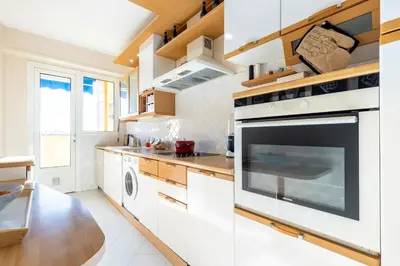 a kitchen with white cabinets and a large oven at Eat - Sleep - Wander Chic and Cosy Flat in Nice