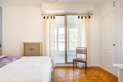 a bedroom with a bed and a chair and a window at Eat - Sleep - Wander Chic and Cosy Flat in Nice