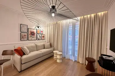 a living room with a couch and a large window at OPERA PROMENADE 2 Renovated 1 min to Beach Air Conditioning in Nice