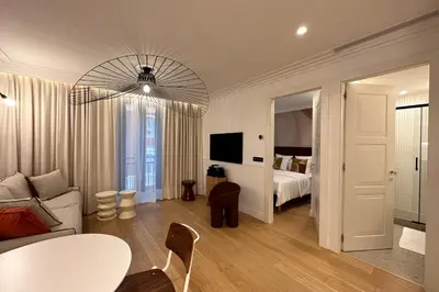 a living room with a couch and a bed and a chandelier at OPERA PROMENADE 2 Renovated 1 min to Beach Air Conditioning in Nice