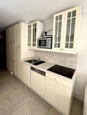 a kitchen with white cabinets and a sink and a microwave at Casa Alessia - Villefranche-sur-mer in Villefranche-sur-Mer