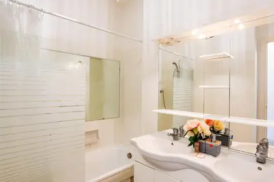 a white bathroom with a sink and a mirror at LE SIRIUS AP4314 By Riviera Holiday Homes in Nice