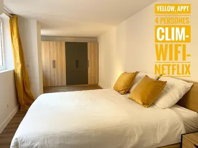 a bedroom with a large white bed with yellow pillows at Homelivia,Industriel cosy in Nice