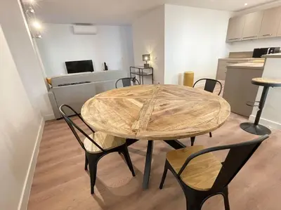 a table and chairs in a room with a kitchen at Homelivia,Industriel cosy in Nice