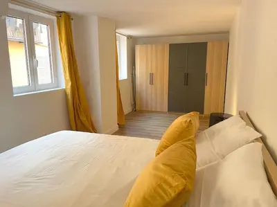 a bedroom with a large white bed with yellow pillows at Homelivia,Industriel cosy in Nice