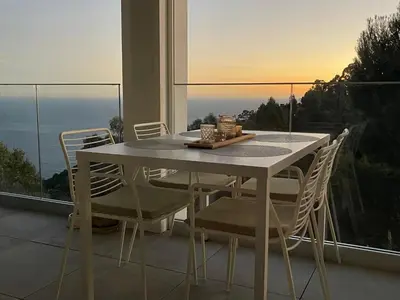 a table and chairs on a balcony with a view at Appartement de luxe Eze village vue mer avec piscine in Èze