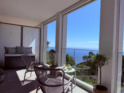 a balcony with a table and chairs and a view of the ocean at Appartement de luxe Eze village vue mer avec piscine in Èze
