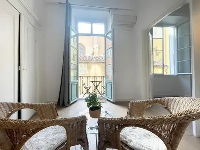 a living room with two chairs and a balcony at Homelivia, VIEUX NICE, appartement de charme, clim balcon in Nice