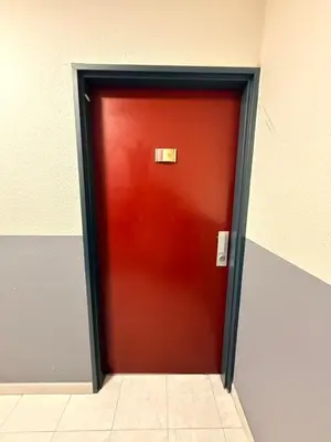 a red door in a building with a sign on it at Studio central avec balcon- Plage - Tram - Aéroport in Nice