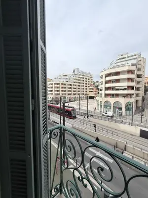 a balcony with a view of a city with a train at Studio central avec balcon- Plage - Tram - Aéroport in Nice