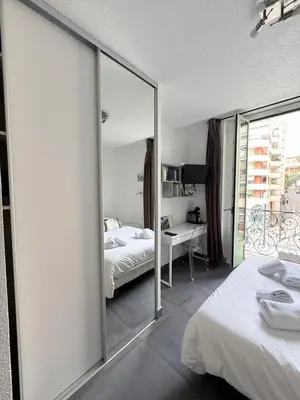a bedroom with a mirror and a bed and a desk at Studio central avec balcon- Plage - Tram - Aéroport in Nice