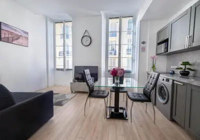 a kitchen and living room with a glass table and chairs at Studio Famous bd Victor Hugo - city center in Nice