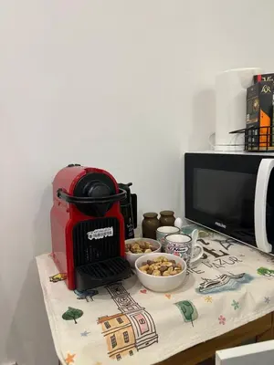 a red toaster sitting on a table with a bowl of food at Cosy studio VIEUX NICE à 2 pas de la MER in Nice