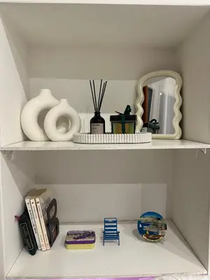a shelf with vases and a mirror and a blue chair at Cosy studio VIEUX NICE à 2 pas de la MER in Nice