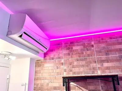 a room with pink lights on a brick wall at Parking + piscine, tout confort, proche aéroport & mer in Saint-Laurent-du-Var