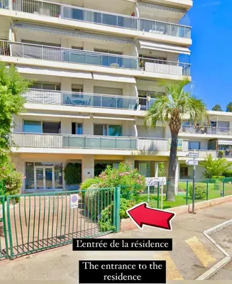 an apartment building with a sign that reads residence the entrance to the resistance at Appartement bord de mer avec piscine in Saint-Laurent-du-Var