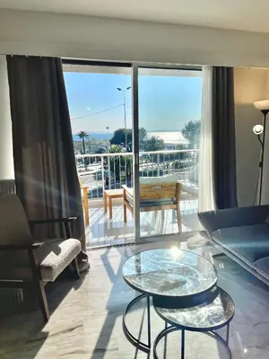 a living room with a view of a balcony at Appartement bord de mer avec piscine in Saint-Laurent-du-Var