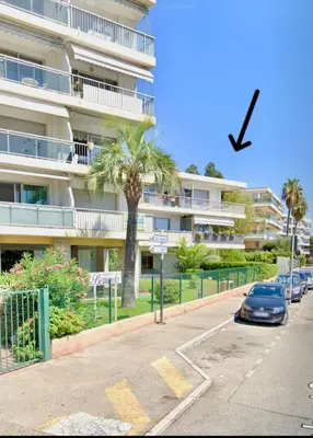 a bird flying over a parking lot in front of a building at Appartement bord de mer avec piscine in Saint-Laurent-du-Var