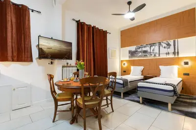 a room with a dining table and a bedroom at La plume de Paul in Nice