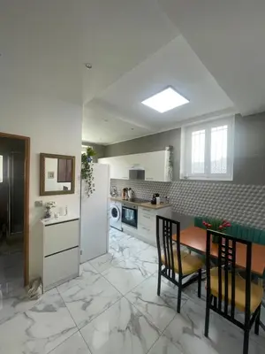 a kitchen with a table and chairs and a refrigerator at Nice Libération in Nice